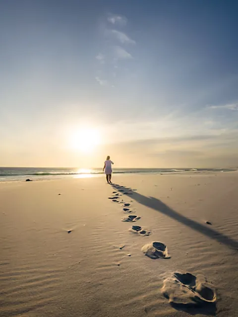 Footprints in the sand toward the sunrise